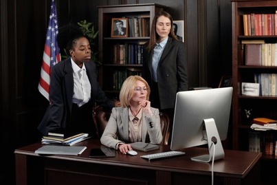 Three professional women collaborating in a law office, illustrating what you can do with a Master of Legal Studies in legal, compliance, and regulatory careers.